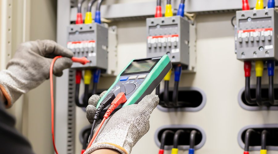 Commercial electrical inspection in Howard County technician testing panel with multimeter