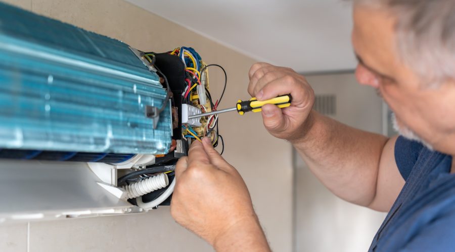 HVAC technician repairing indoor air conditioning unit wiring during service call in Severna Park MD