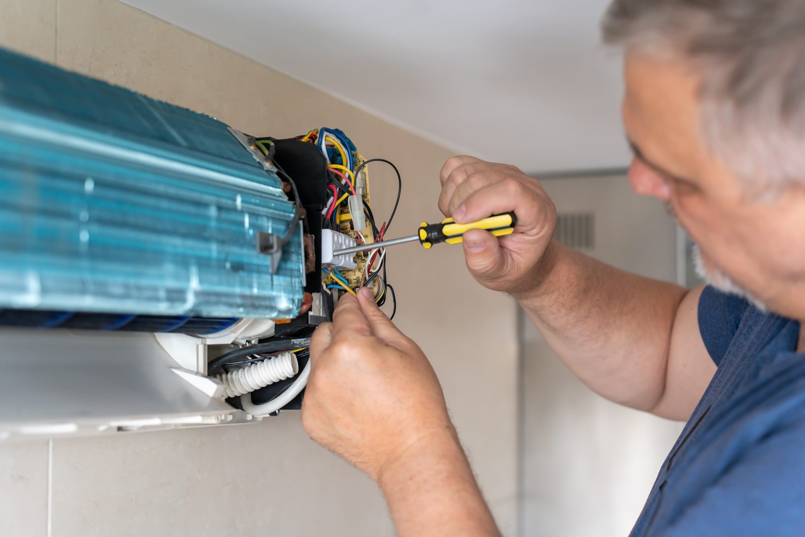HVAC technician repairing indoor air conditioning unit wiring during service call in Severna Park MD