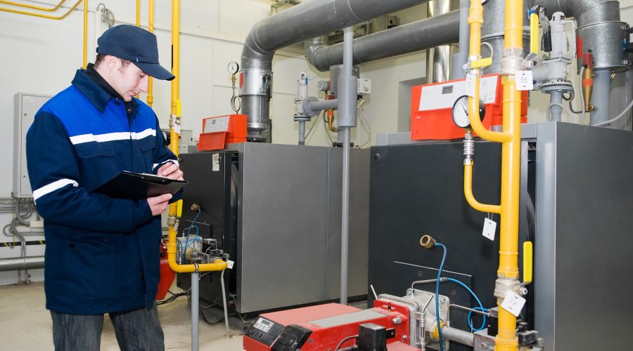 commercial boiler maintenance Germantown MD technician inspecting industrial heating system gauges.