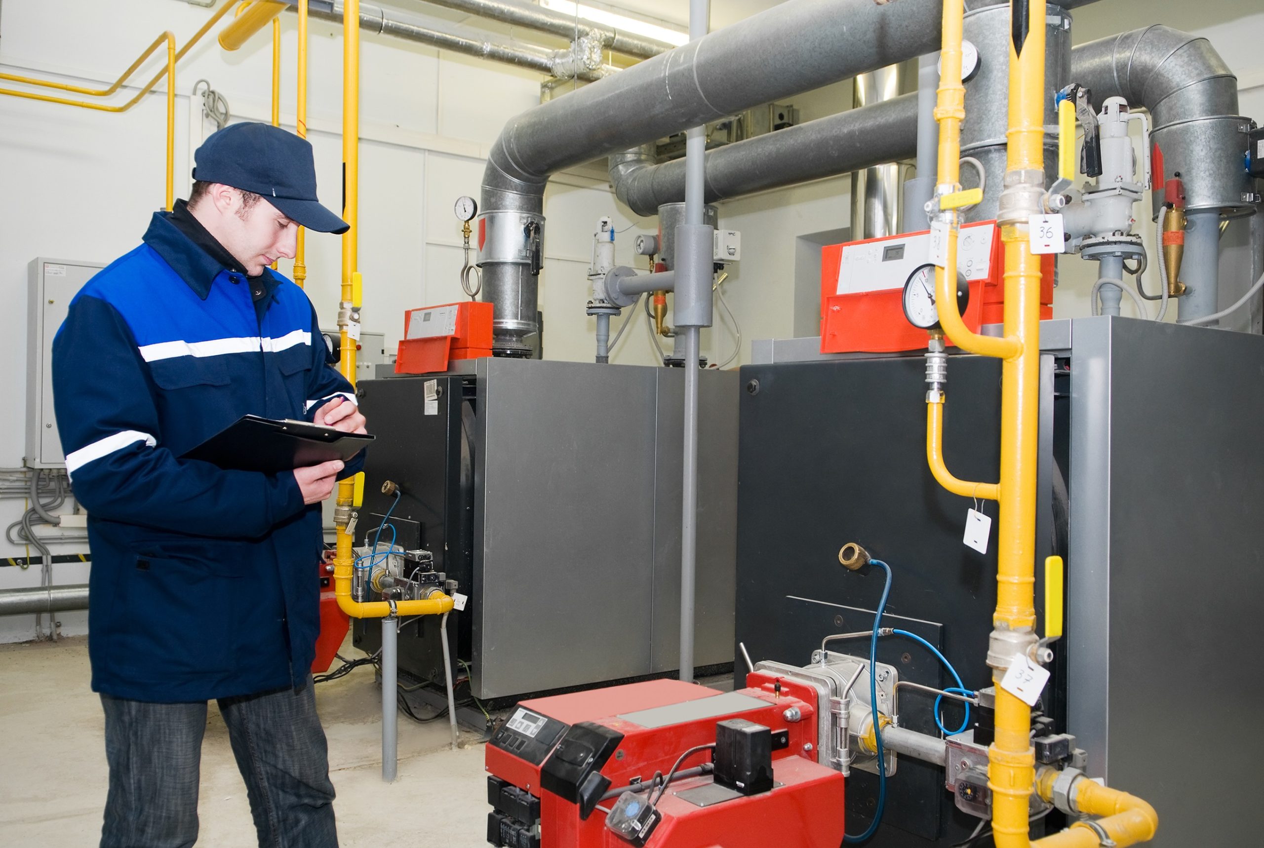 commercial boiler maintenance Germantown MD technician inspecting industrial heating system gauges.