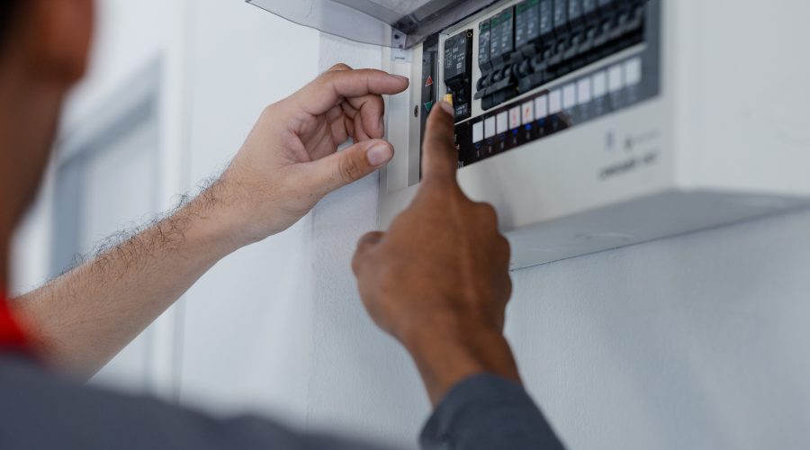 electrical safety inspection in Washington DC electrician checking circuit breaker panel before home sale.