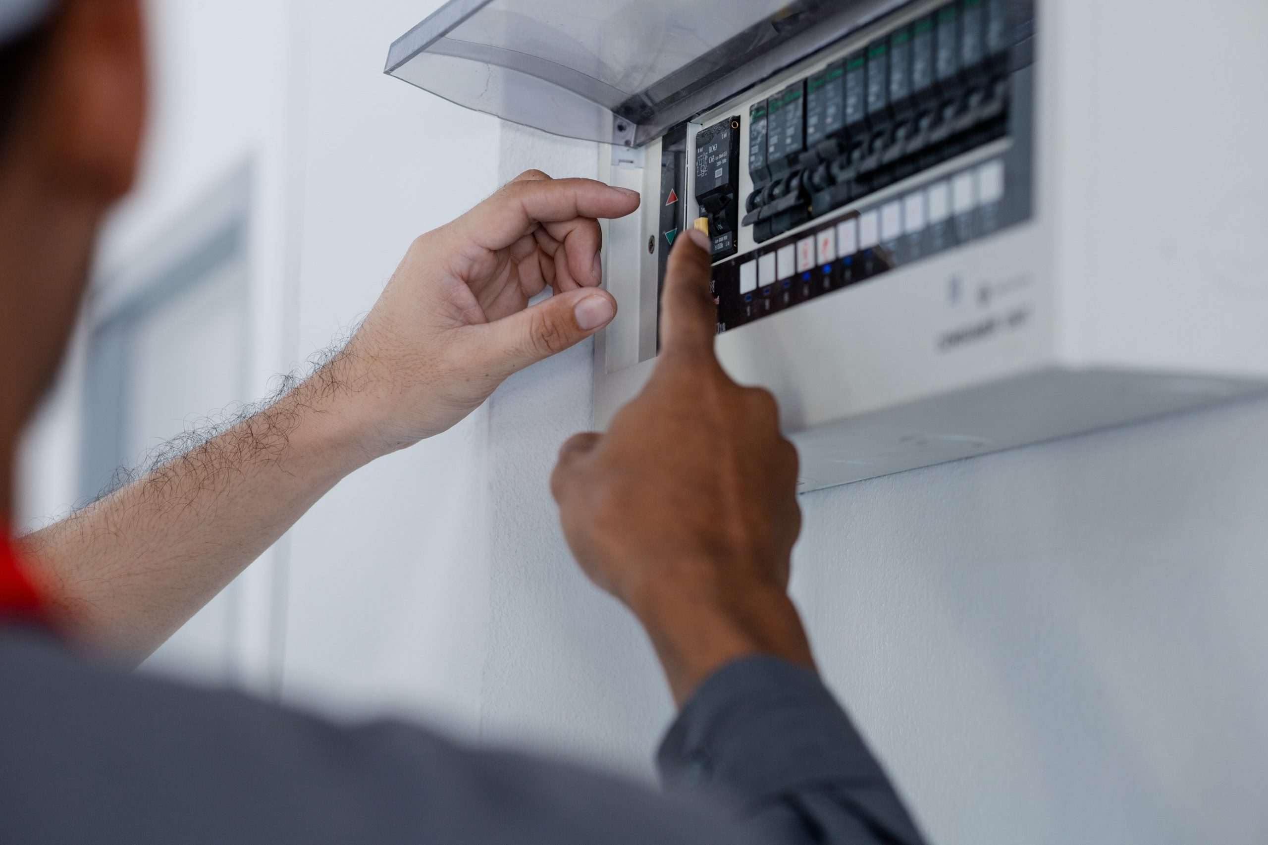 electrical safety inspection in Washington DC electrician checking circuit breaker panel before home sale.