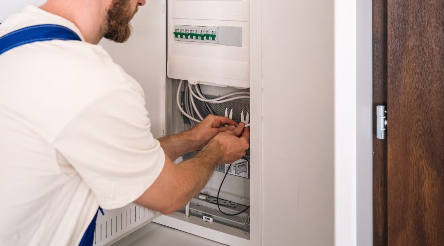 Electrician performing residential electrical services on a home electrical panel.