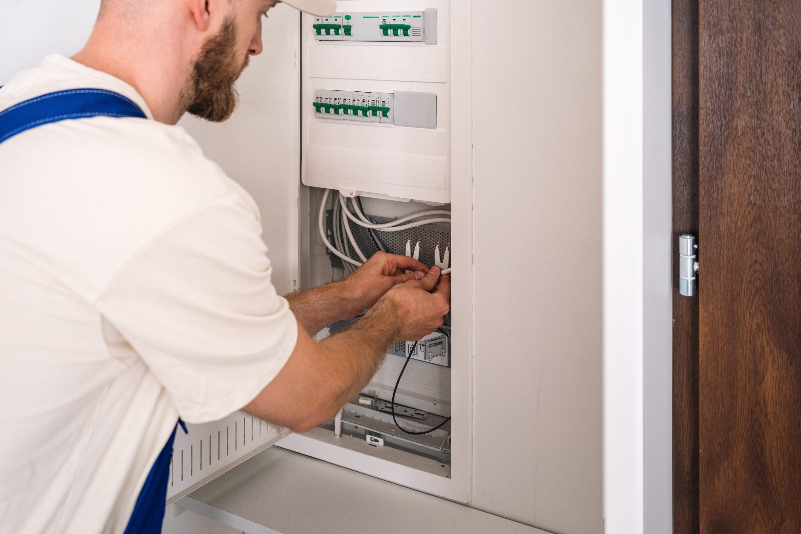 Electrician performing residential electrical services on a home electrical panel.