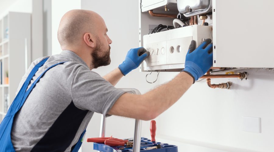 HVAC technician working on a residential boiler during heating system maintenance